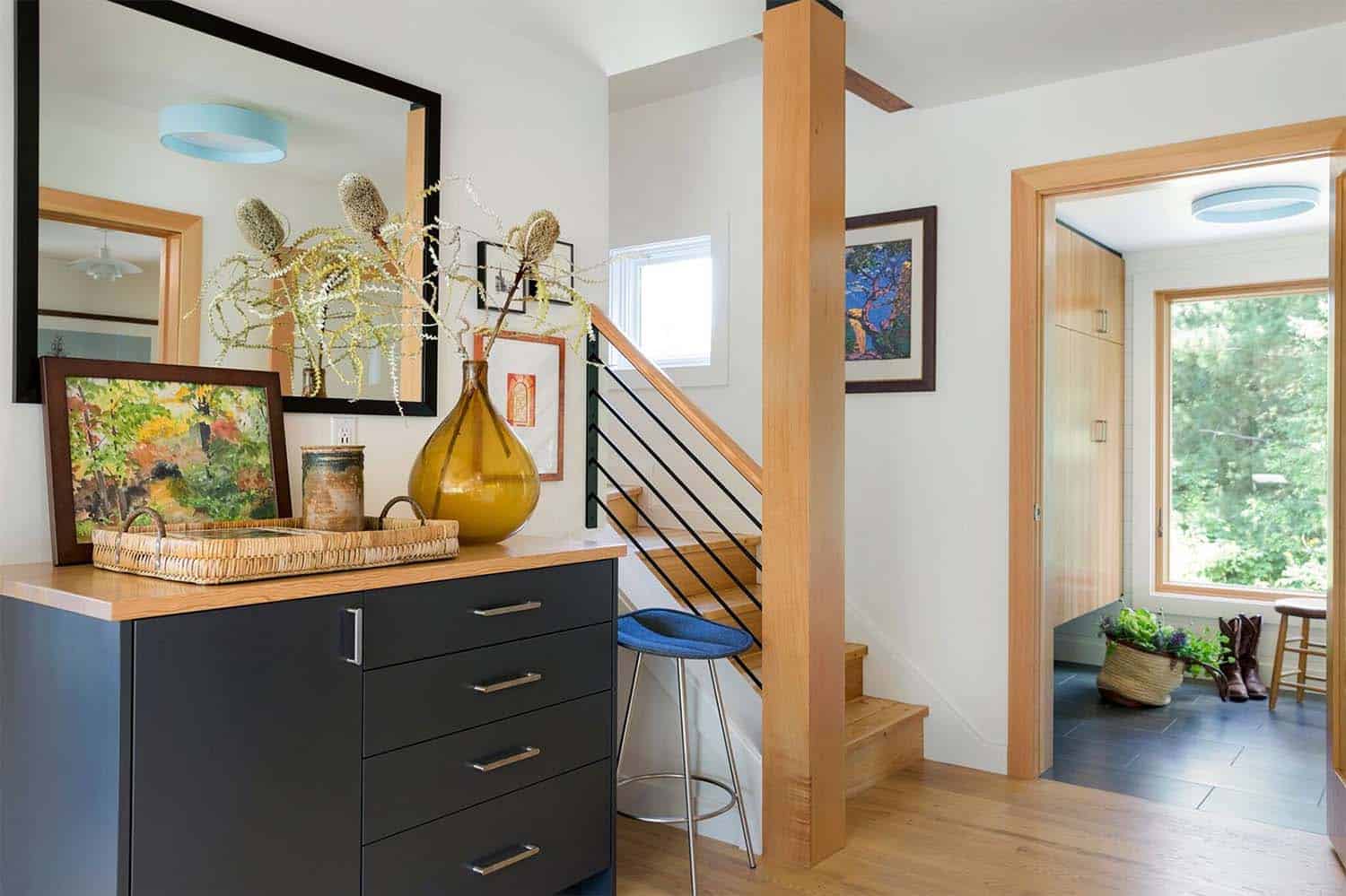 midcentury modern entry with a console table and staircase