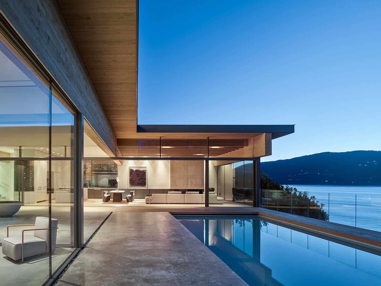 minimalist home exterior with a pool at dusk