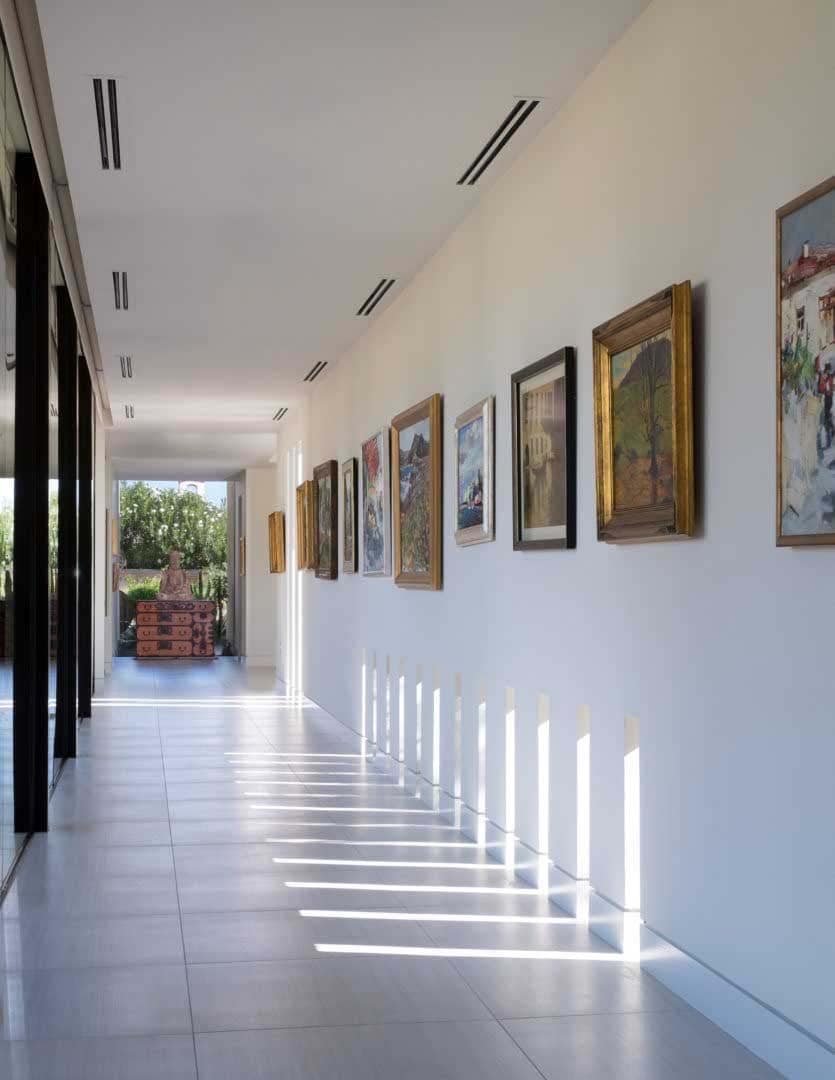 modern hallway with a wall of art and floor-to-ceiling glass