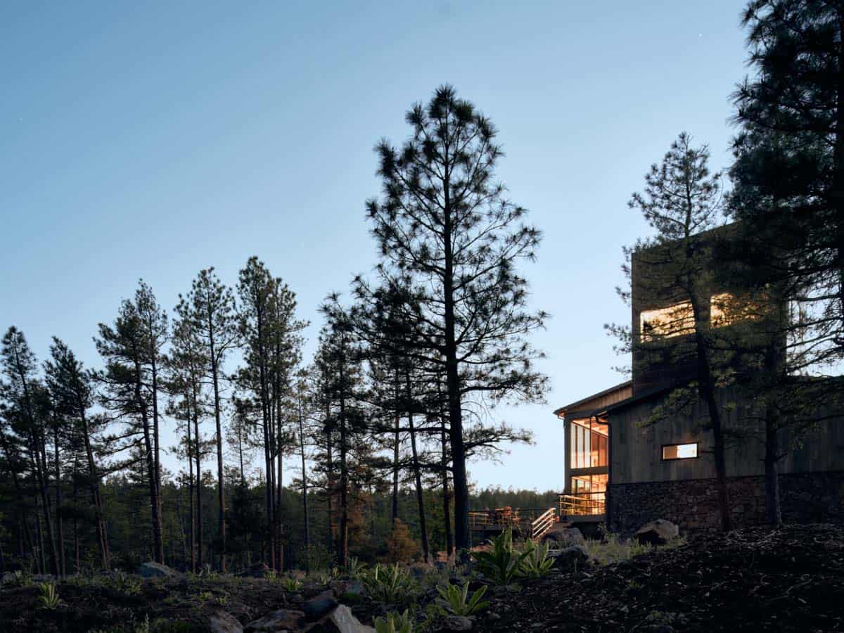 mountain modern house with a tower in a ponderosa forest at dusk