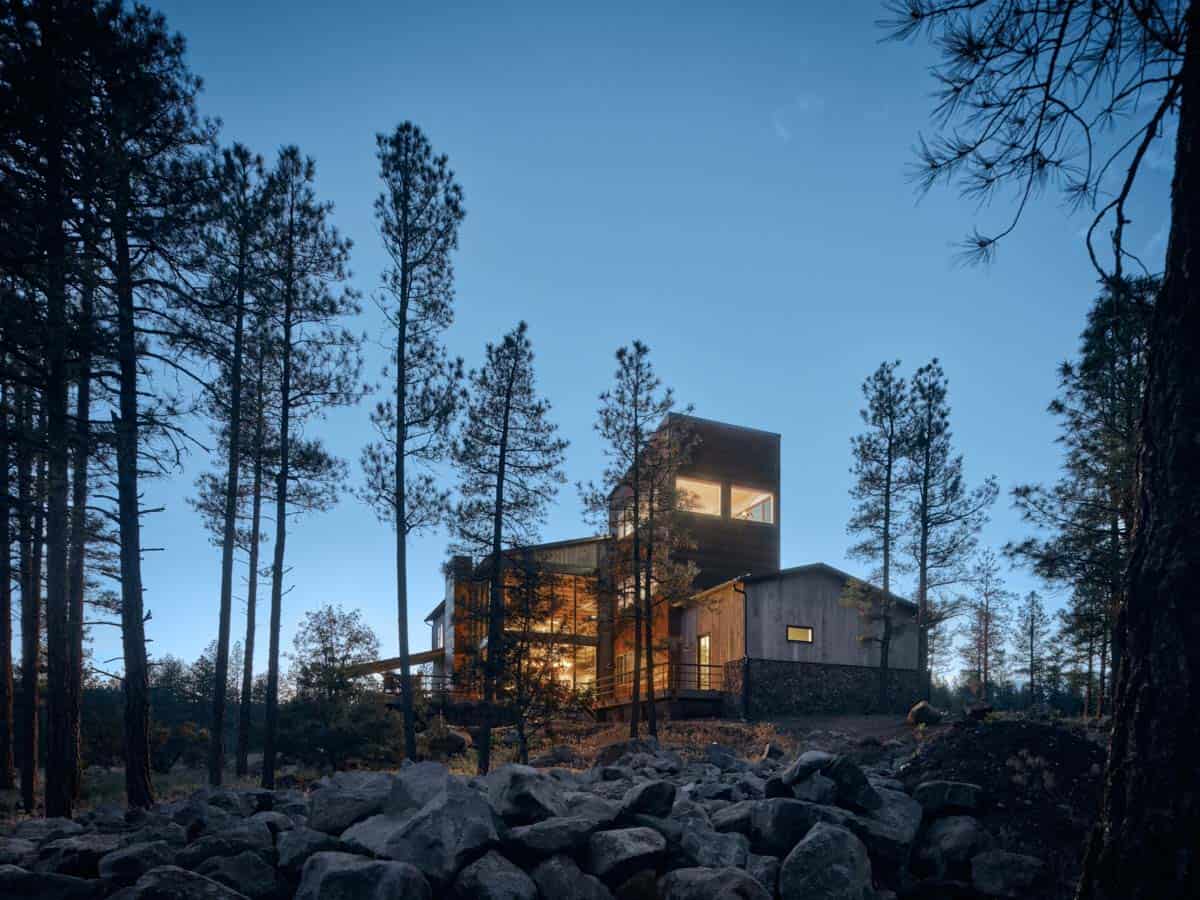 mountain modern house with a tower in a ponderosa forest at dusk