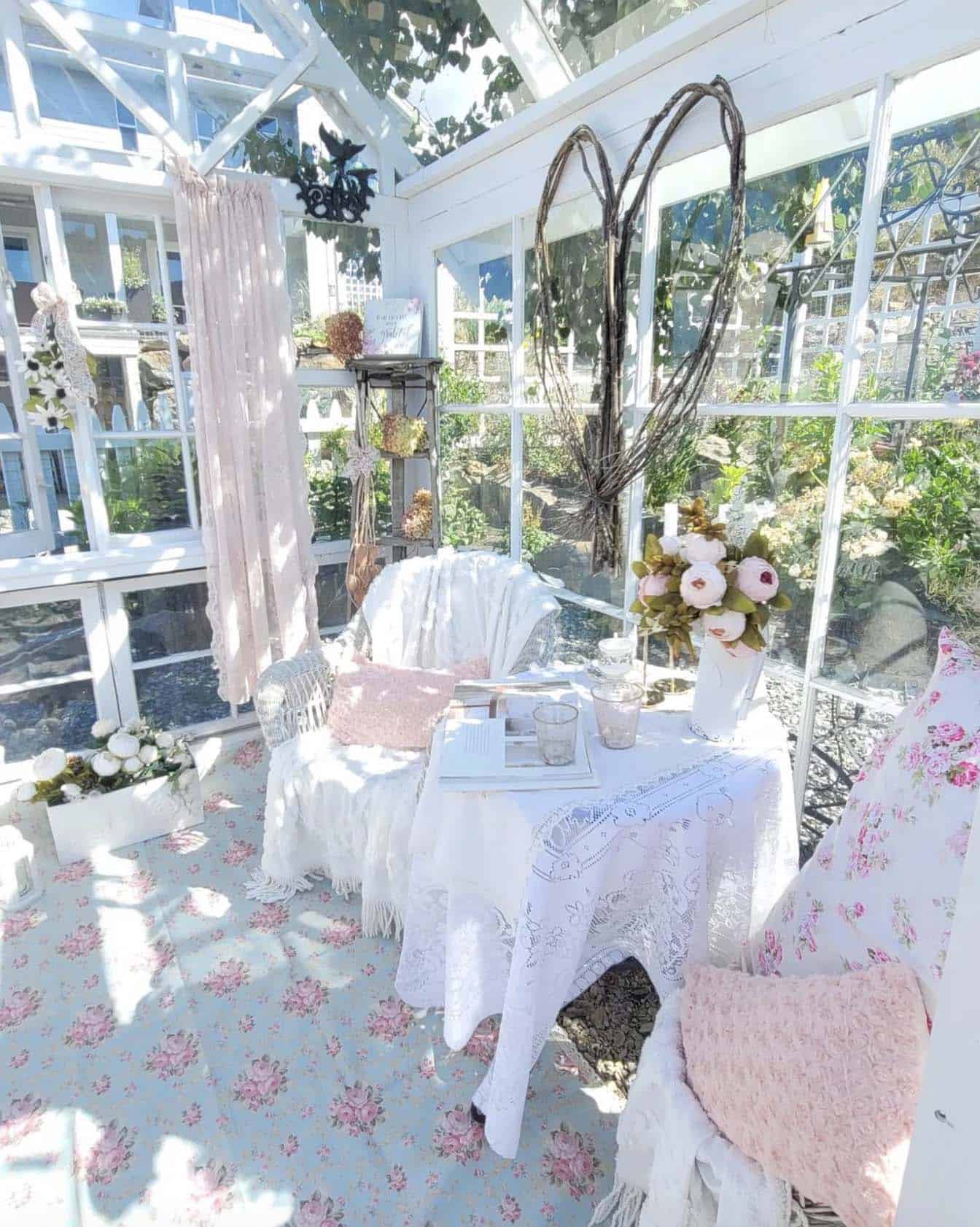 she shed greenhouse decorated in pink and white with a table and chairs