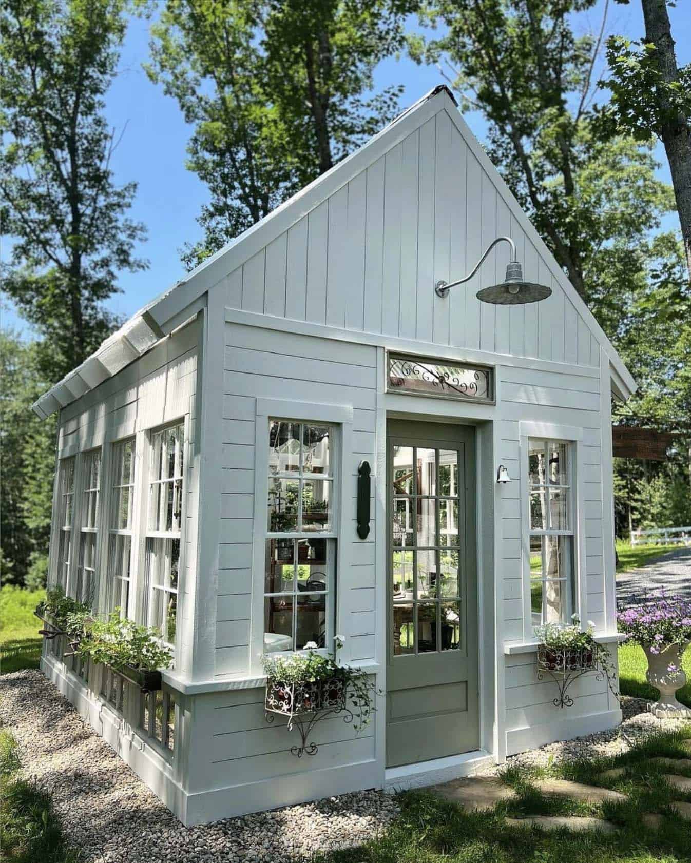 greenhouse exterior painted white with old windows and doors