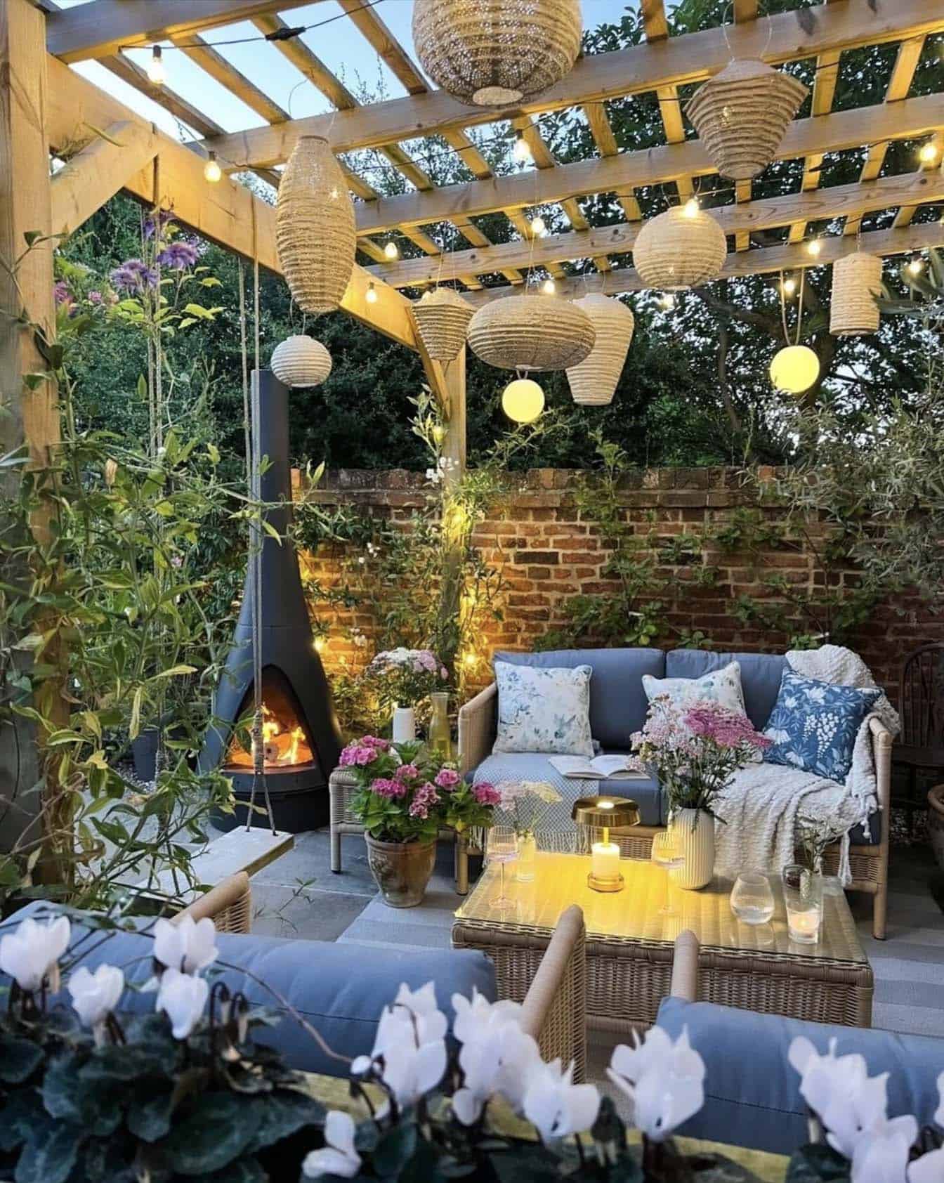 backyard patio with a trellis, outdoor furniture, and fireplace stove