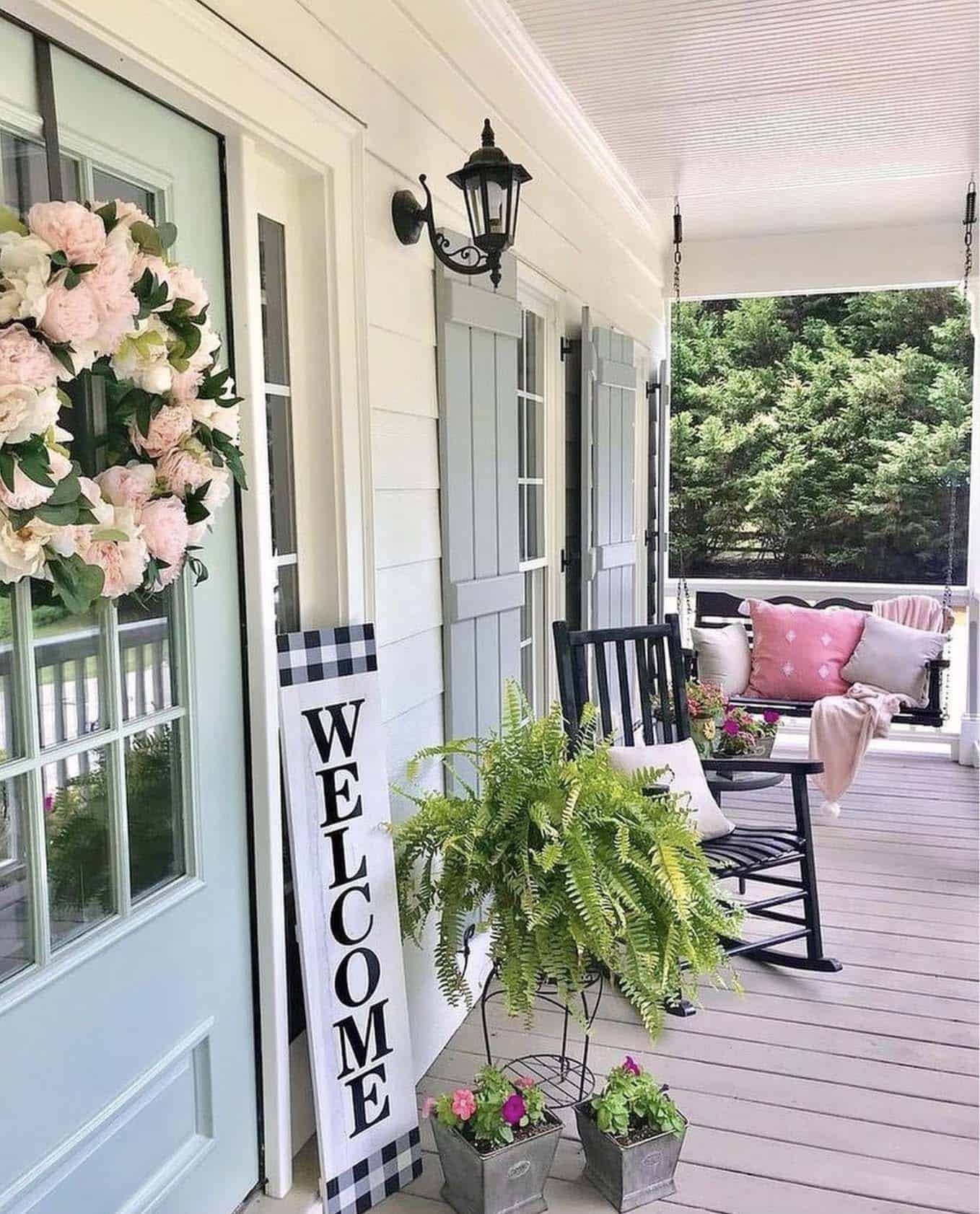 farmhouse style front porch with a blue door and rocking chair