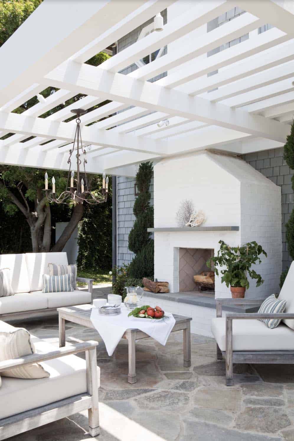 beach style patio with a pergola and fireplace