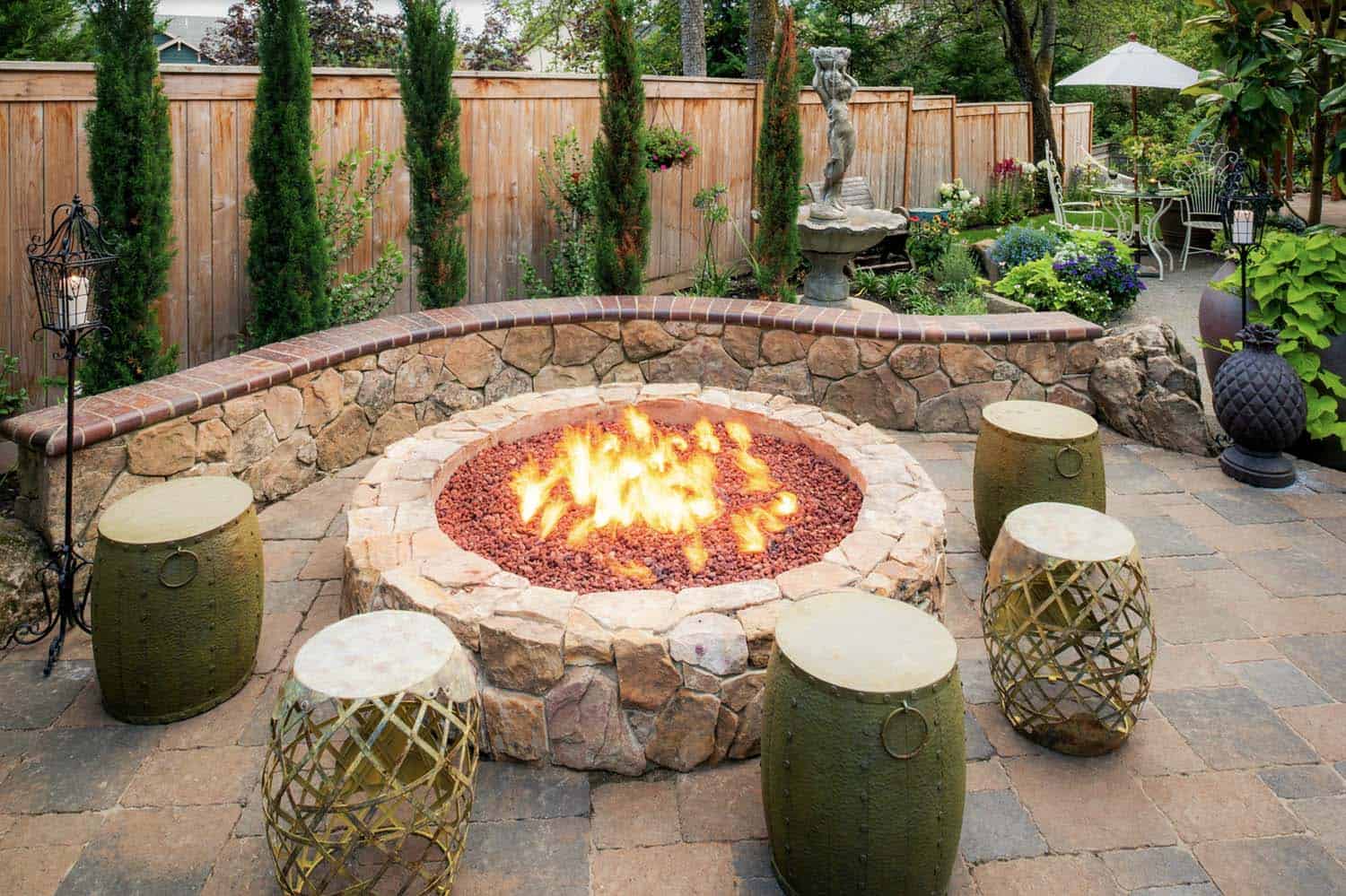 mediterranean style patio with an outdoor fire pit and garden stools