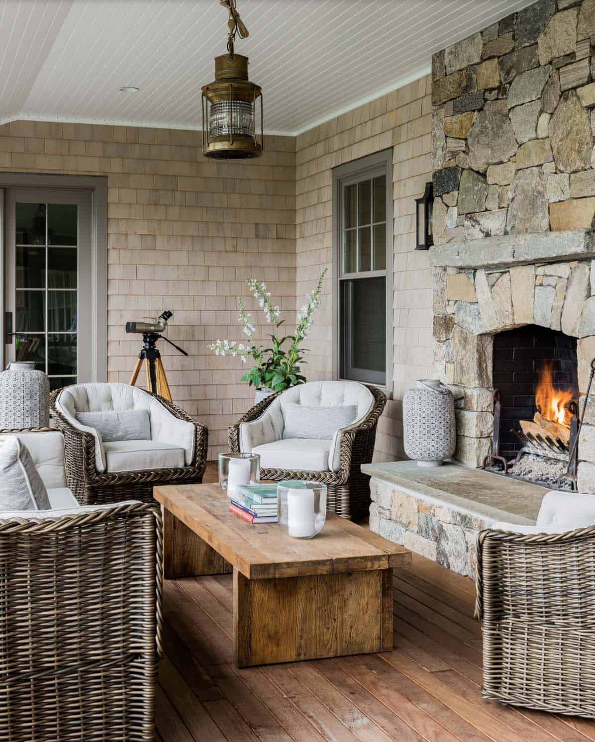 beach style porch with a fireplace and wicker furniture