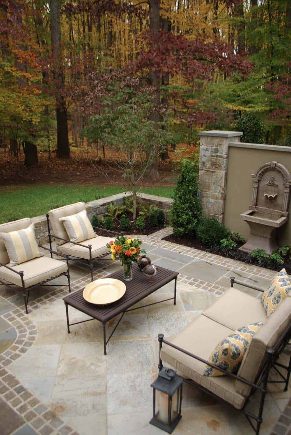 outdoor living space with iron furnishings and a water fountain