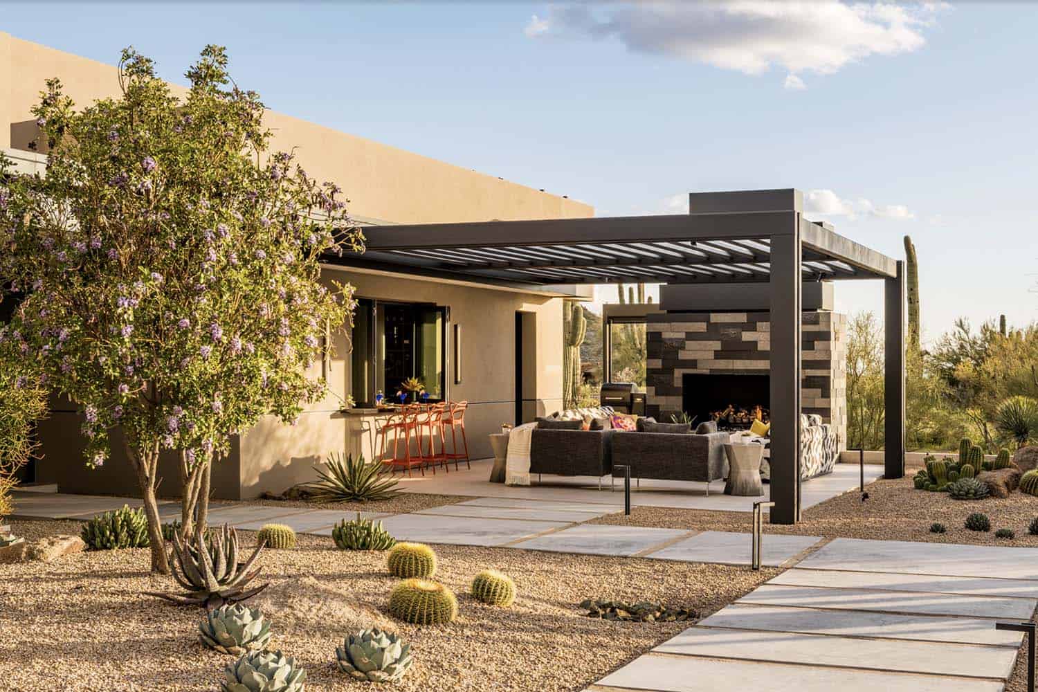 modern desert house backyard with a trellis and fireplace