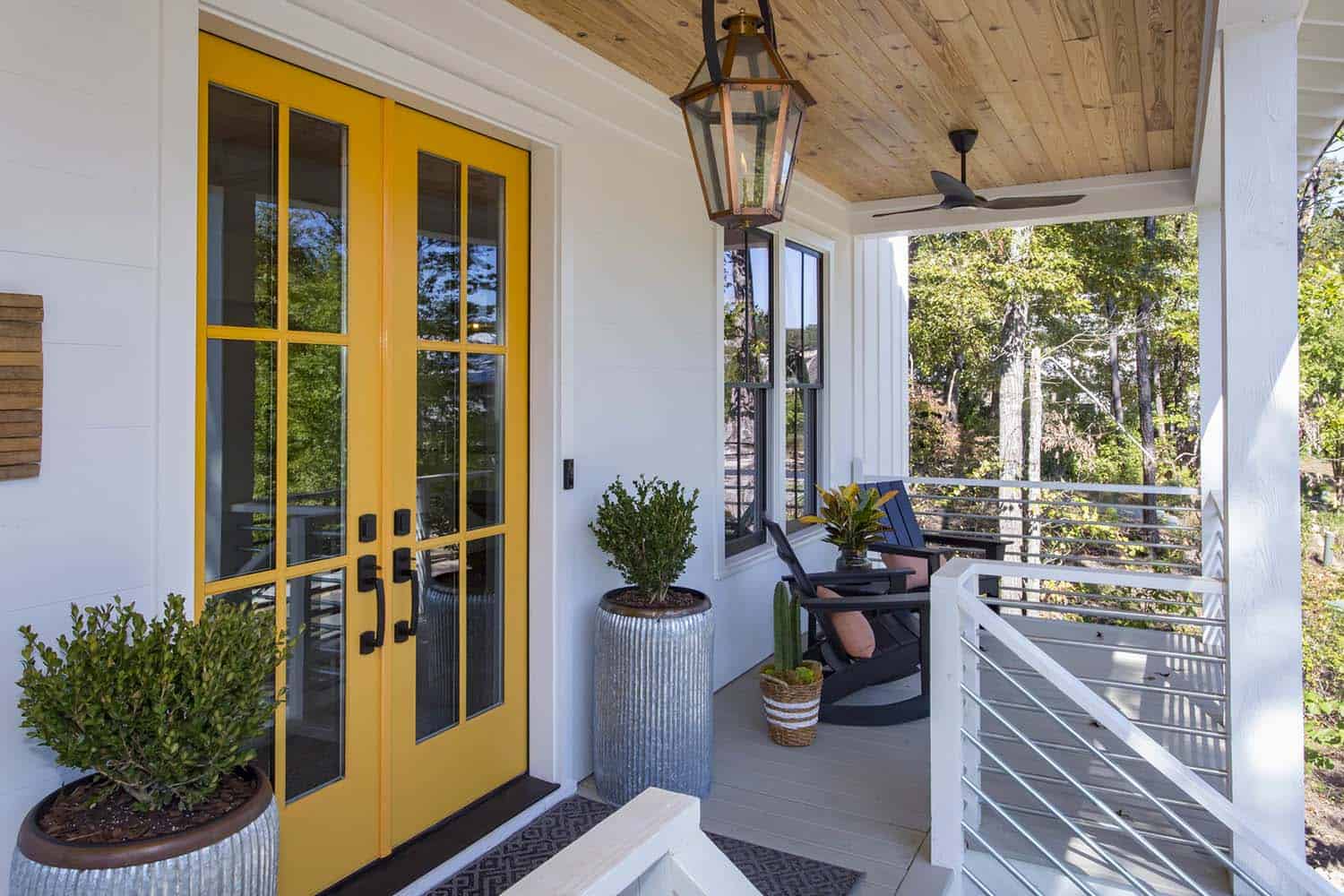 modern farmhouse home front porch with a yellow entry door