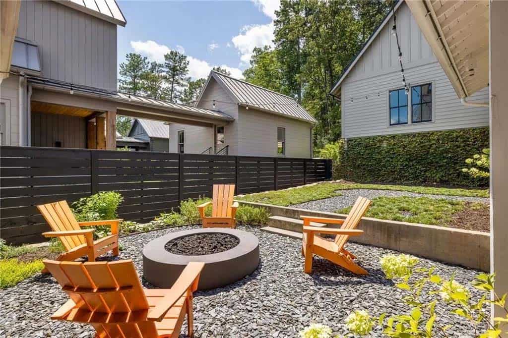 modern farmhouse home backyard patio with a fire pit and Adirondack chairs