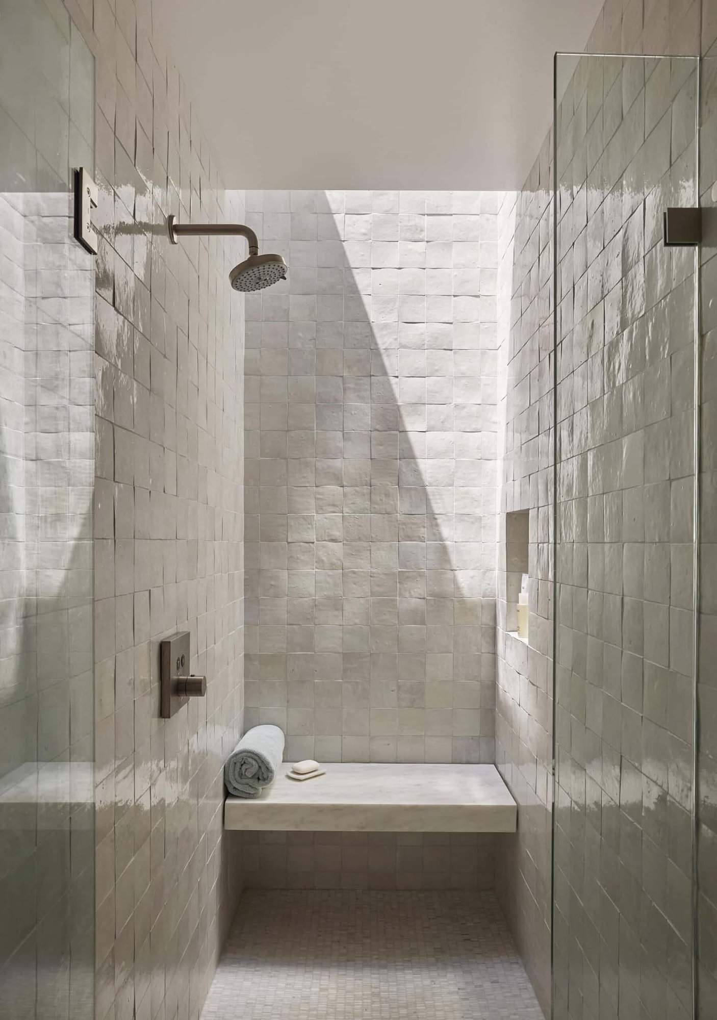 modern bathroom with white tiles and a skylight