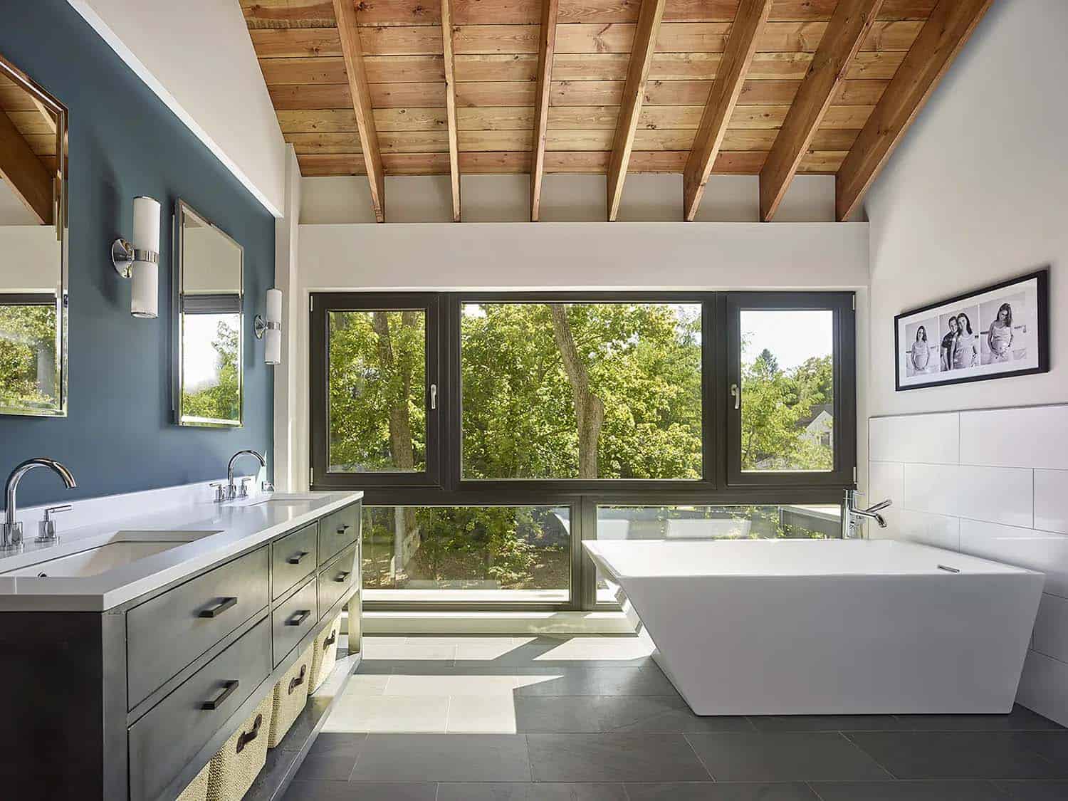 contemporary bathroom vanity and freestanding tub with a large window