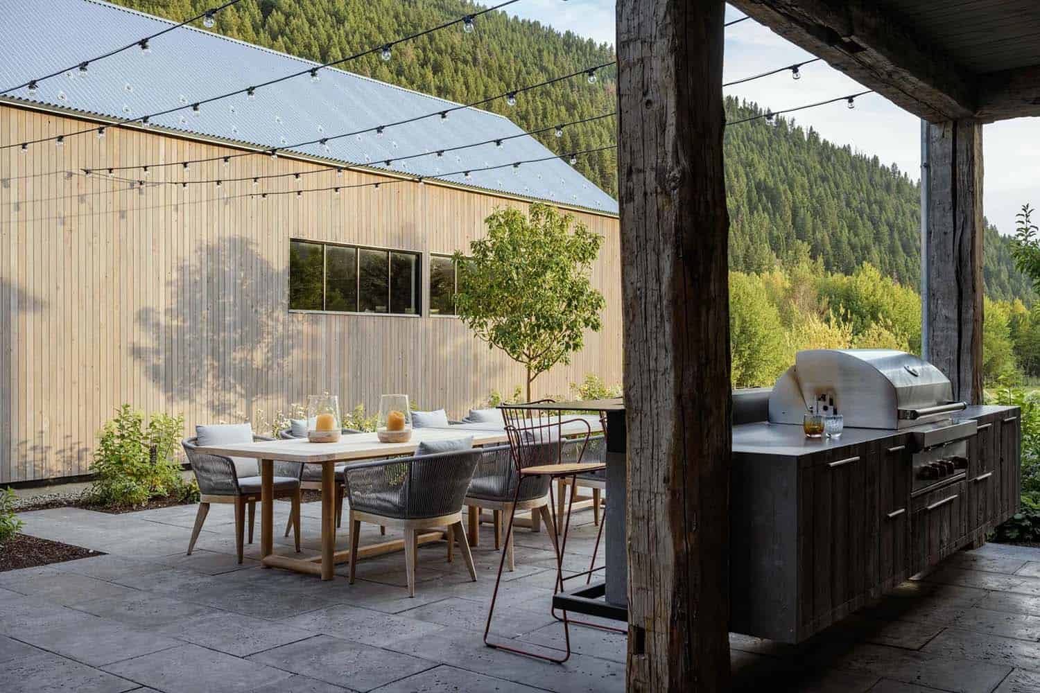 mountain home backyard with an outdoor dining table and kitchen