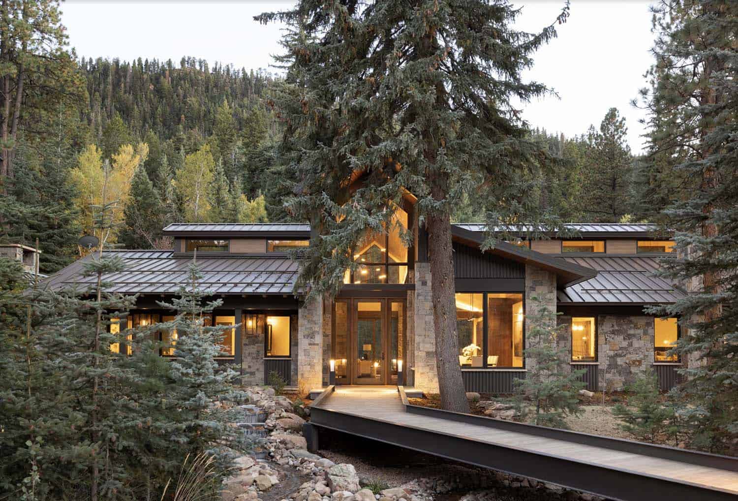 modern rustic mountain home exterior at dusk