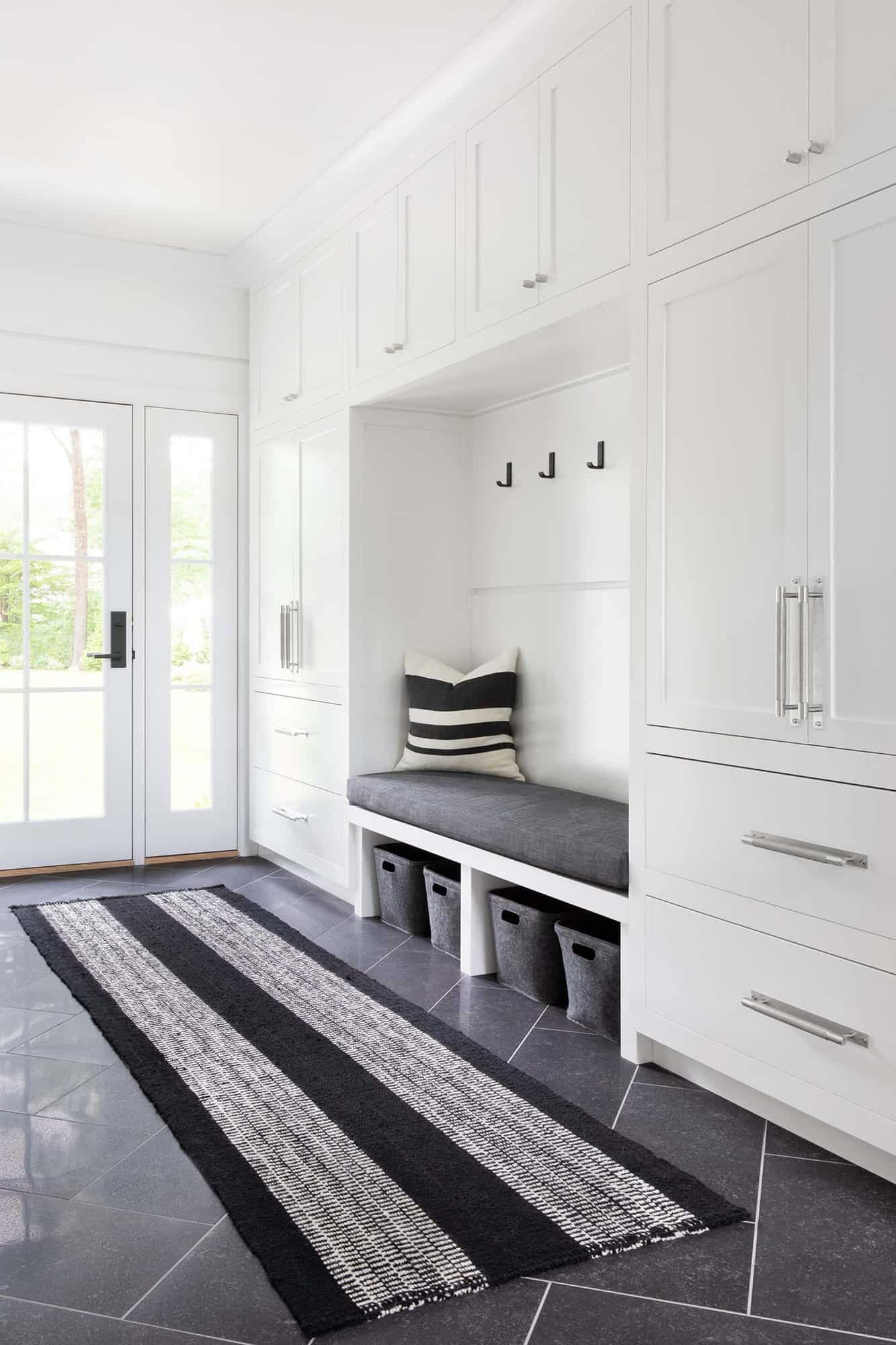 transitional style mudroom with a built-in bench and storage cabinets