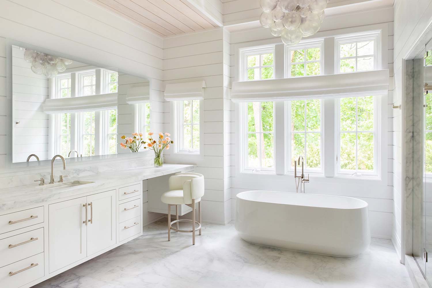 transitional style bathroom with a makeup vanity and freestanding tub