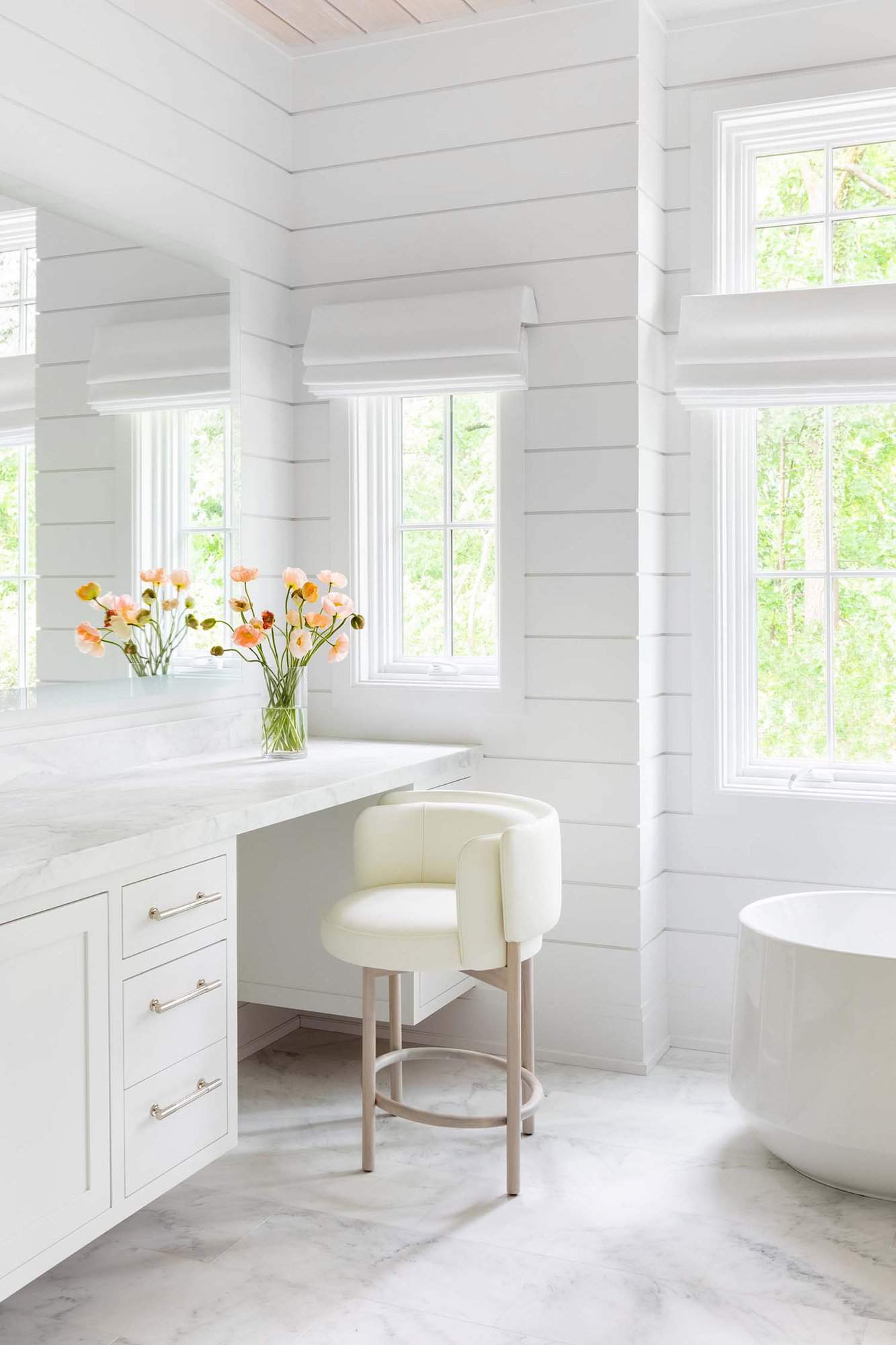 transitional style bathroom with a makeup vanity and freestanding tub